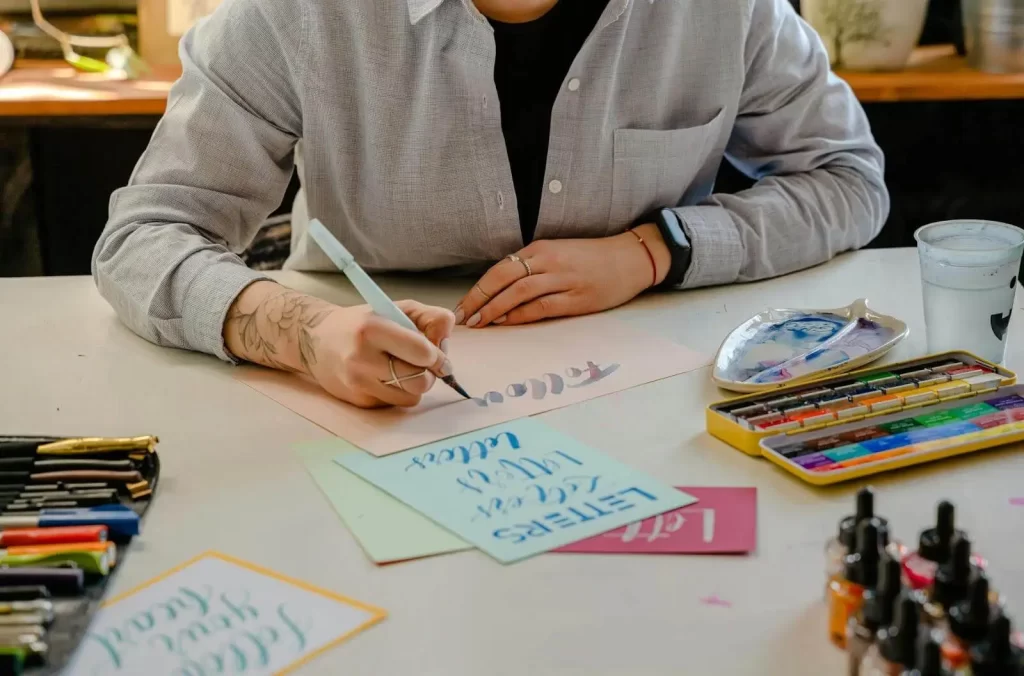 Una persona che fa calligrafia usando una penna a pennello