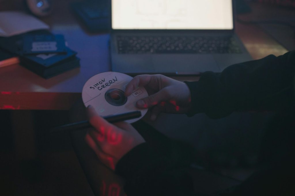 An image of a person holding a CD and a CD Marker Pen