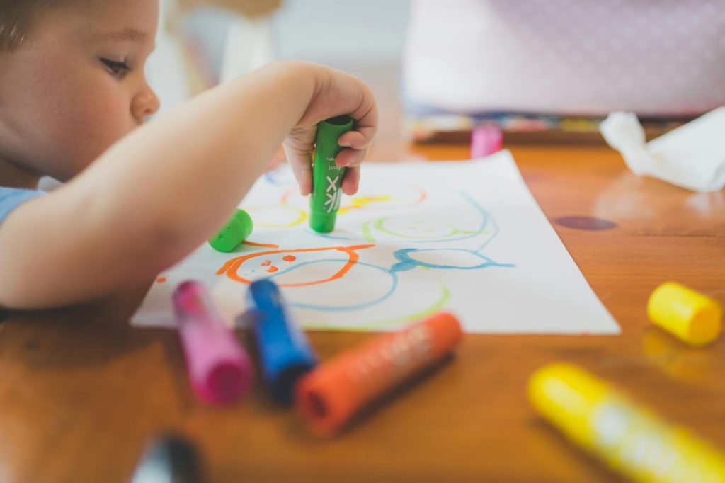 Obrazek przedstawiający dziecko rysujące na papierze za pomocą nietoksycznych markerów